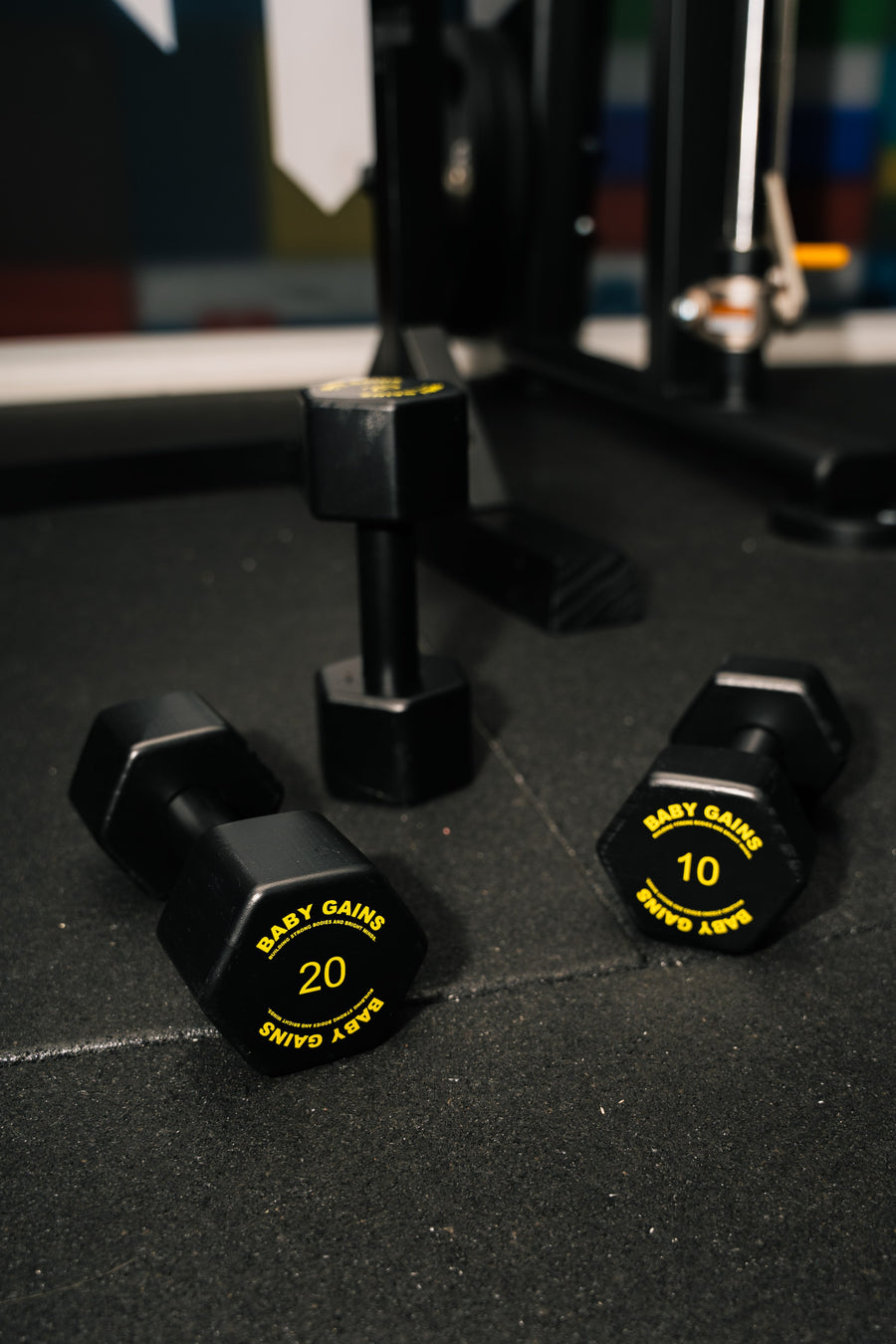 Baby Gains kids dumbbells 20 and 10 on a gym floor