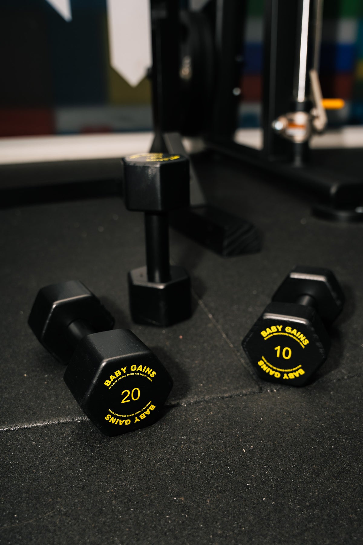 Baby Gains kids dumbbells 20 and 10 on a gym floor