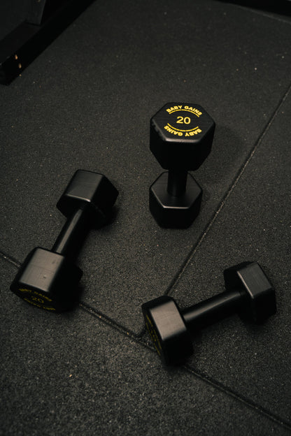 Baby Gains kids hex dumbbells lying and standing on a gym floor