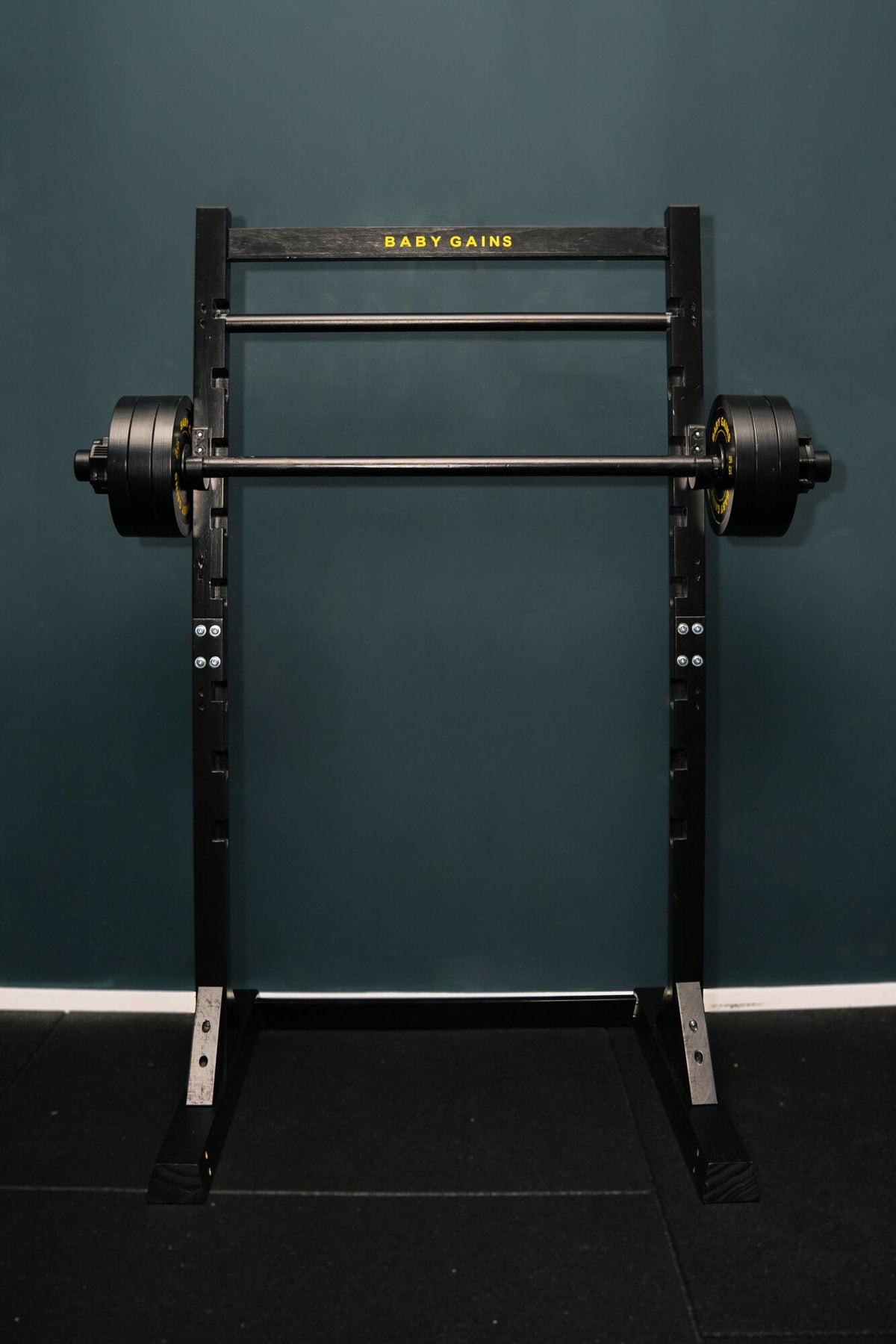 Kids Squat, Bench & Pull-Up Station, black frame with Baby Gains top bar, barbell with plates on the J-hooks, front view