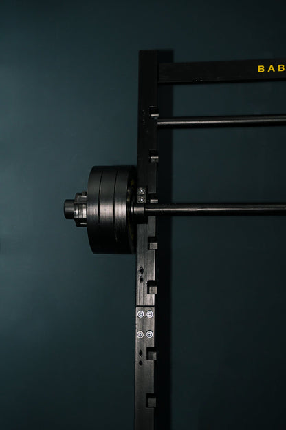 Side view of the Kids Squat, Bench & Pull-Up Station with a loaded barbell on the J-hooks