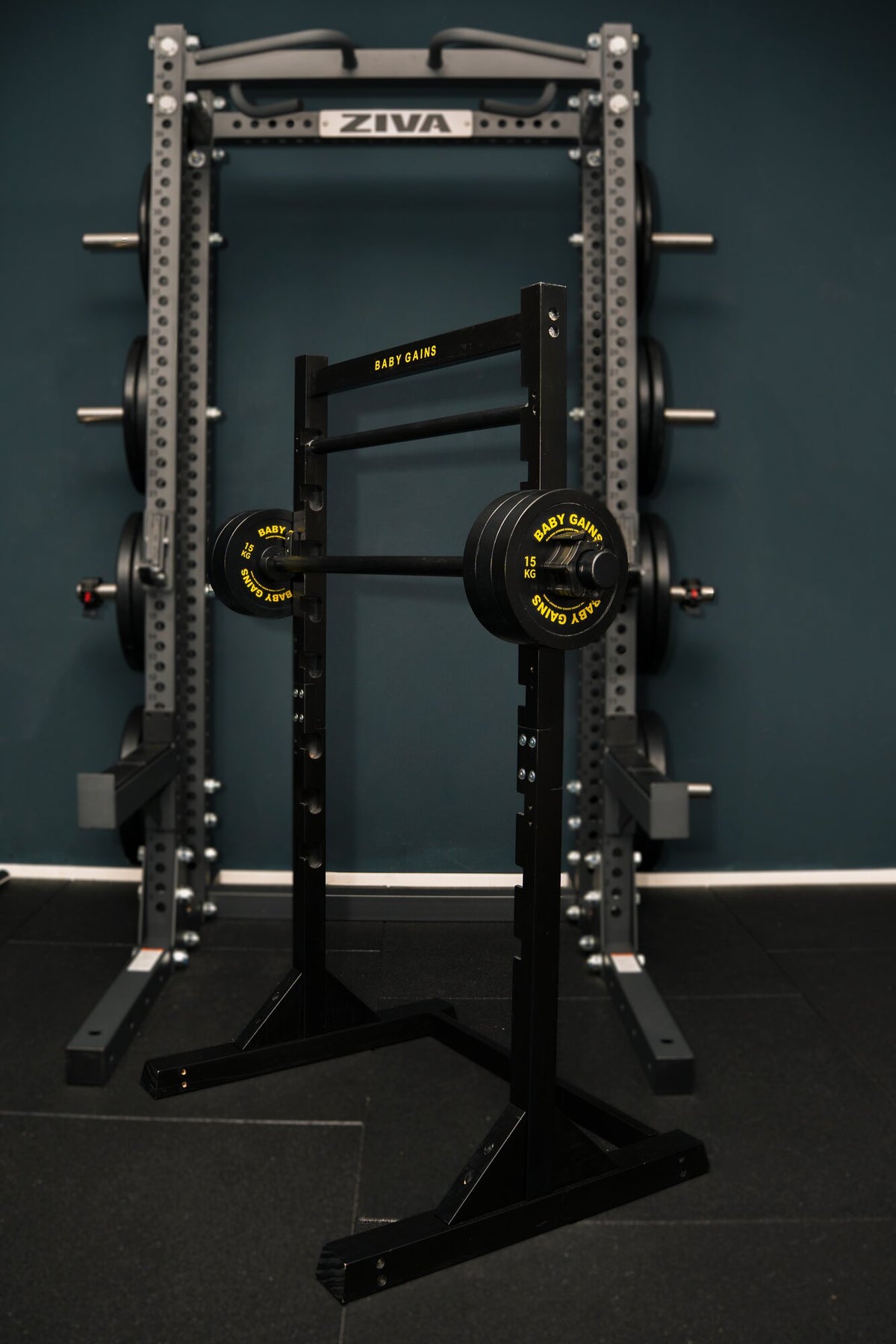 Kids Squat, Bench & Pull-Up Station standing inside an adult power rack, showing its size