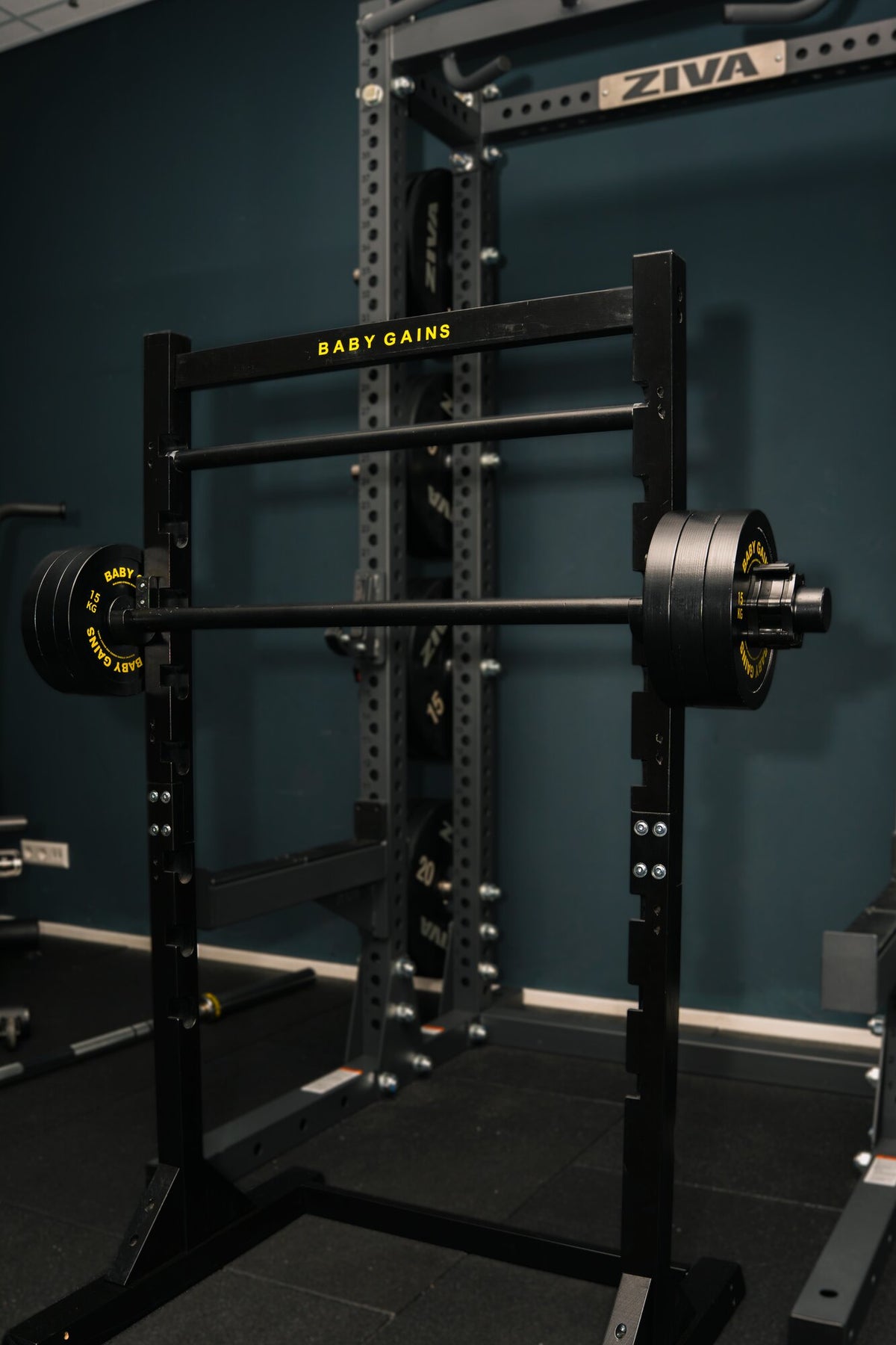 Kids Squat, Bench & Pull-Up Station with a loaded barbell in a home gym, next to an adult rack
