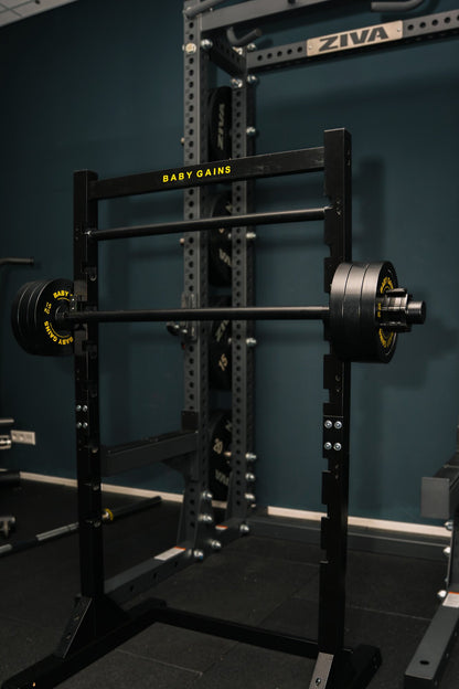 Kids Squat, Bench & Pull-Up Station with a loaded barbell in a home gym, next to an adult rack